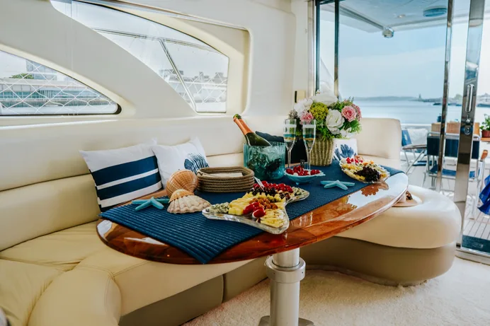 Recepção a bordo com espumante e mesa de boas-vindas no lounge do Gênesis XI