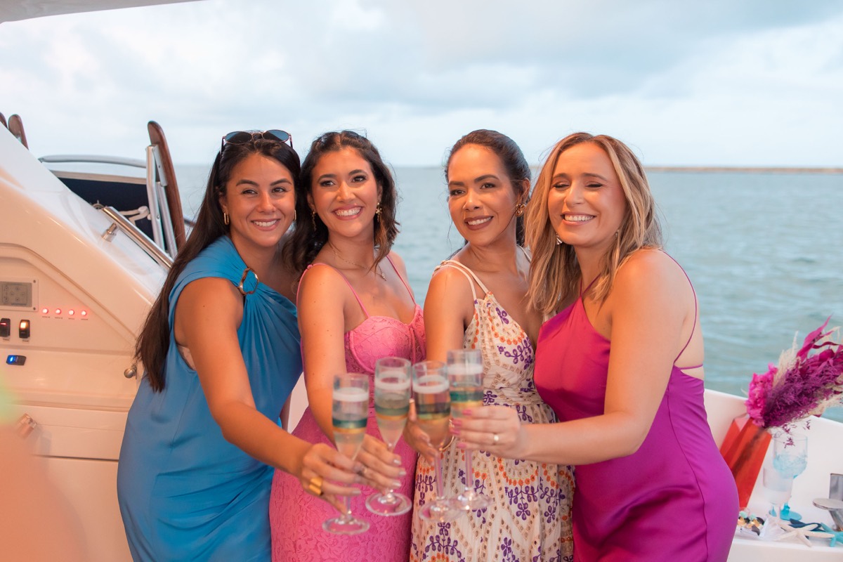 Amigas brindam com espumante na proa de um iate durante celebração exclusiva da Recife Boats